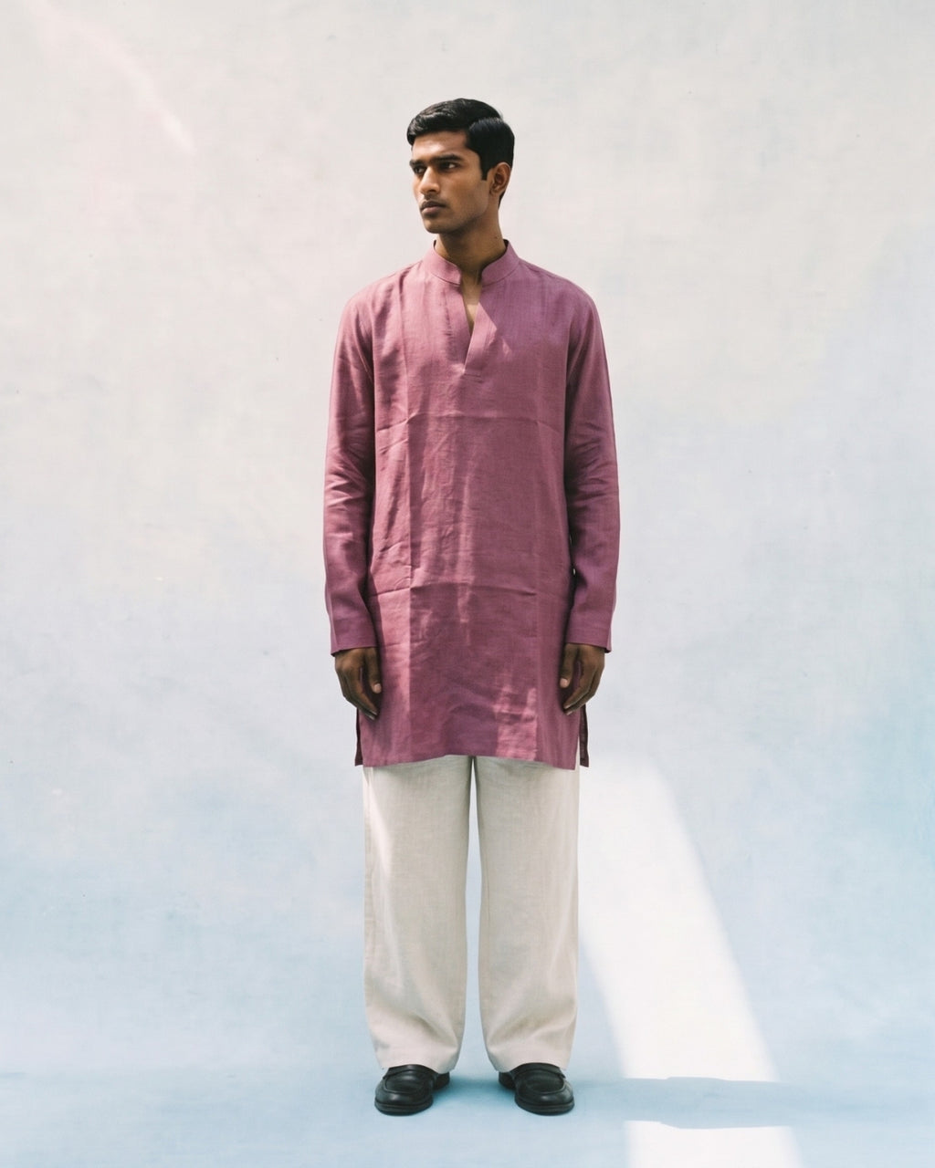 Pastel Maroon linen kurta with a band collar, long sleeves, short button placket, side slits, and a relaxed straight fit, paired with white linen trousers.