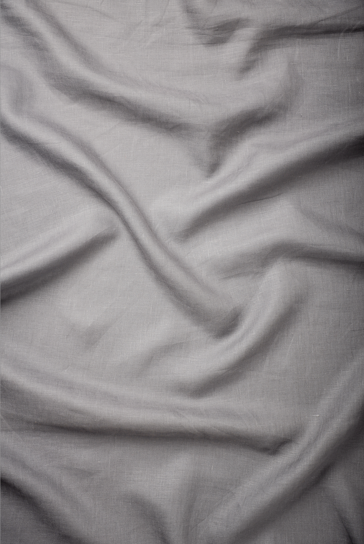 Light grey premium linen fabric with a fine weave and natural creasing, perfect for modern men’s shirts and versatile everyday wear