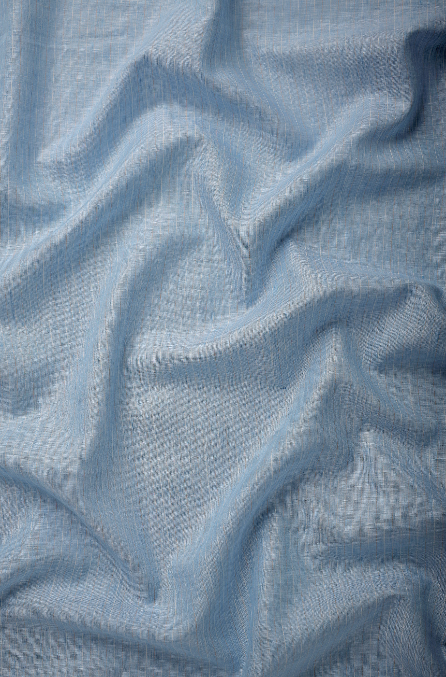 Light blue linen fabric with a smooth, breathable weave and soft natural drape, captured to reveal texture and tonal depth