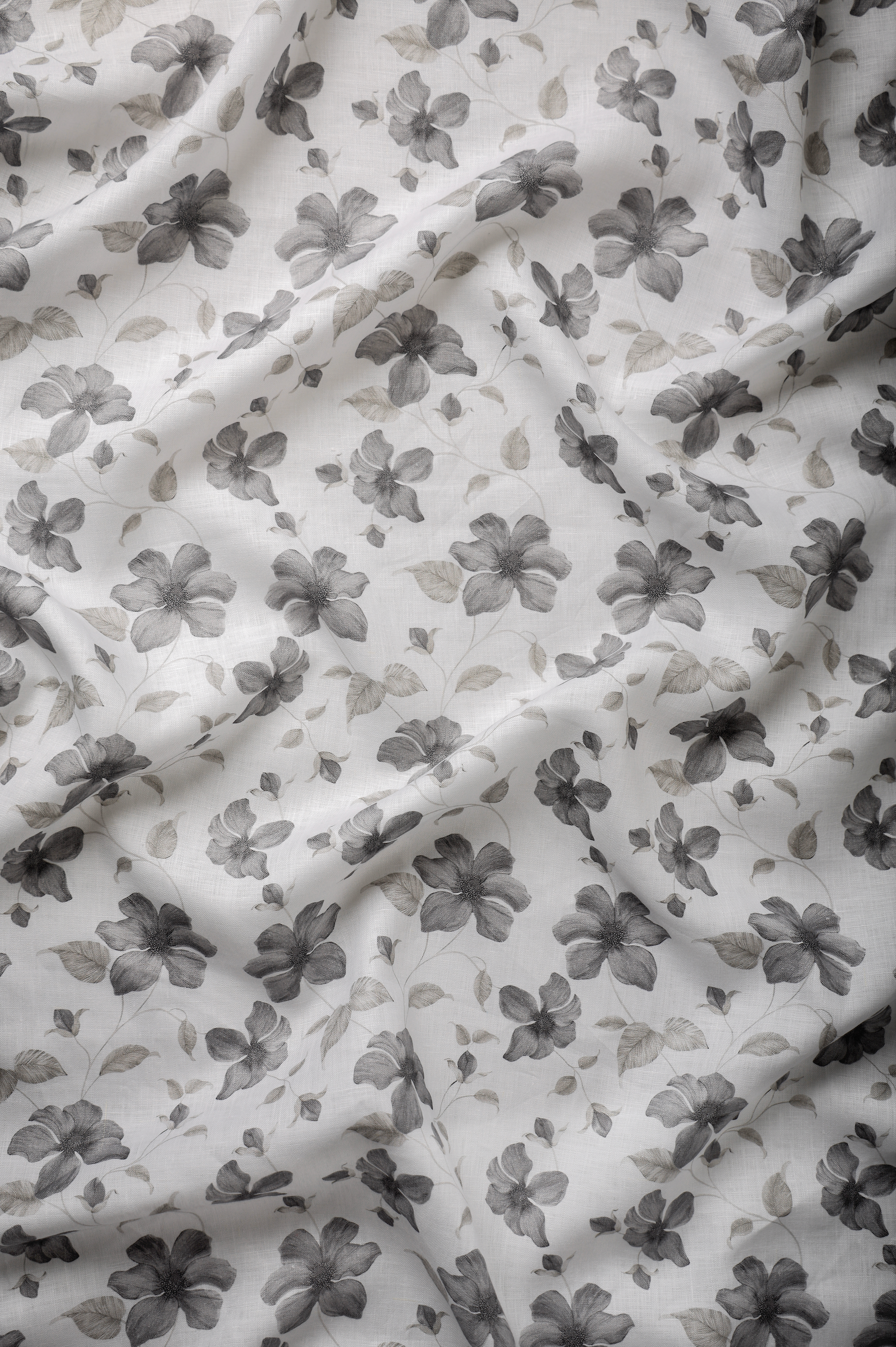 White linen fabric with a delicate grey floral print, featuring a soft hand feel, balanced print placement, and a lightweight flowing texture