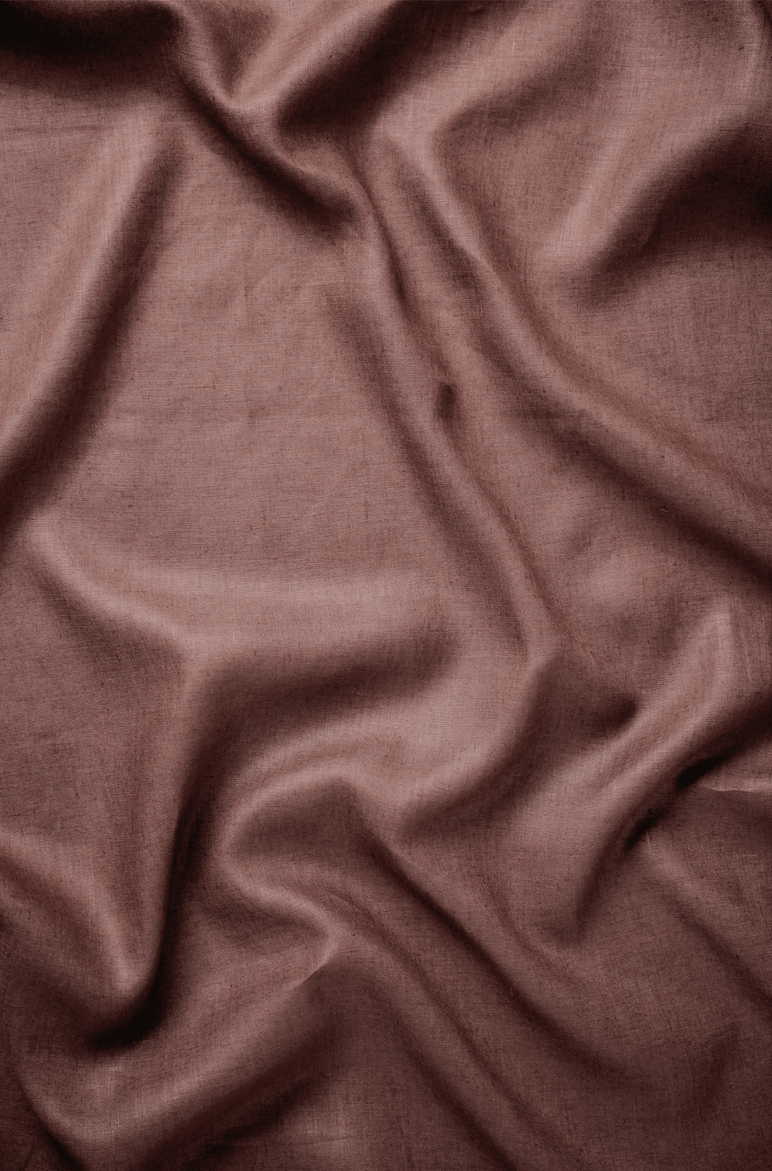 Flat lay of Kāyā 60 lea pure linen fabric in dusty rose with gentle undulations, showing the weave. Sold by the metre by Tyra