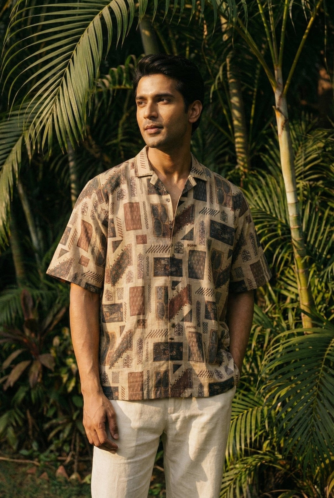 Man in side sunlight against a lush garden, wearing the Lokchitra printed pure linen shirt by Tyra