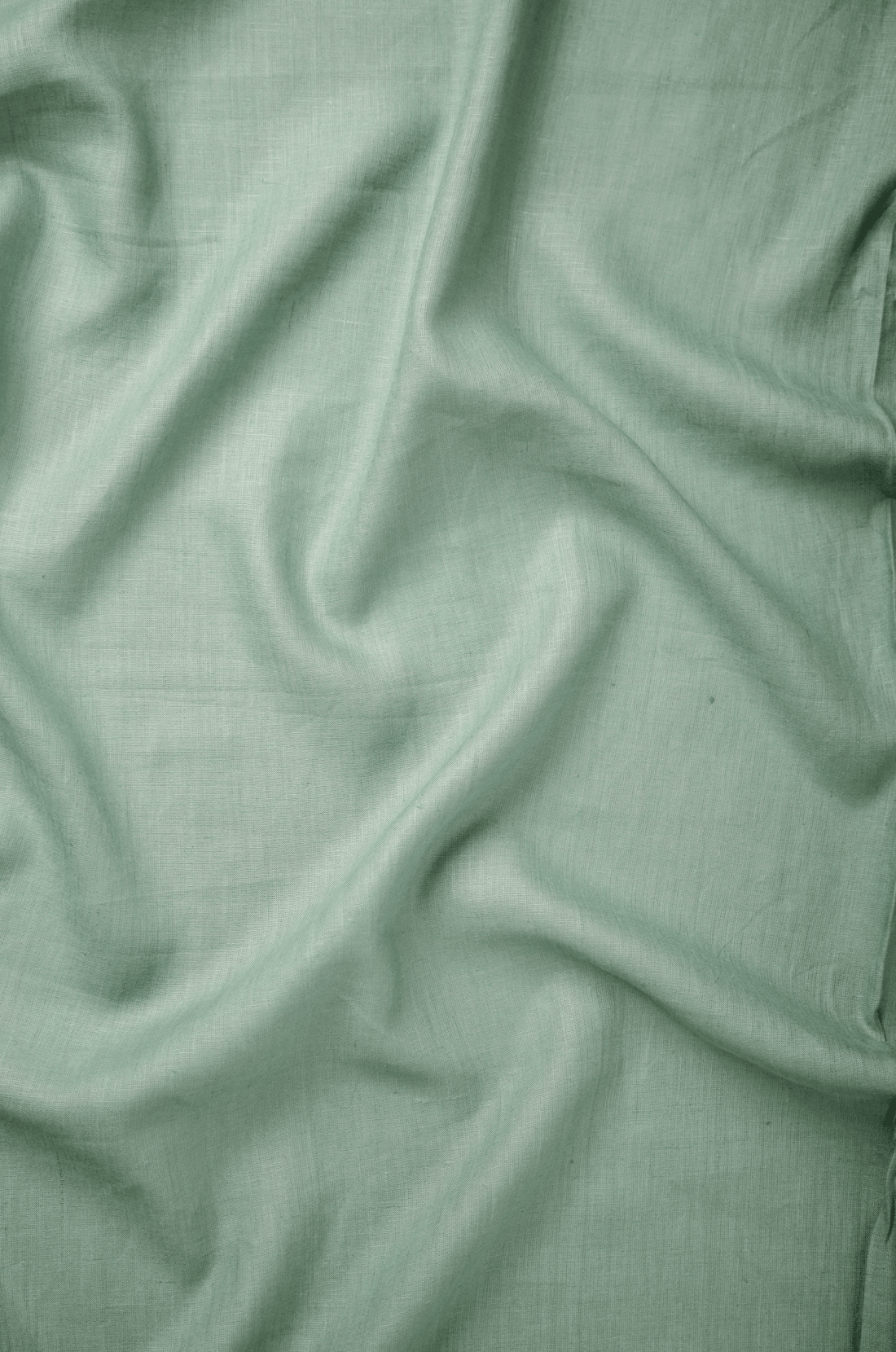 Flat lay of Mārāla Teal 60 lea pure linen fabric in soft sage-teal, showing the weave. Sold by the metre by Tyra