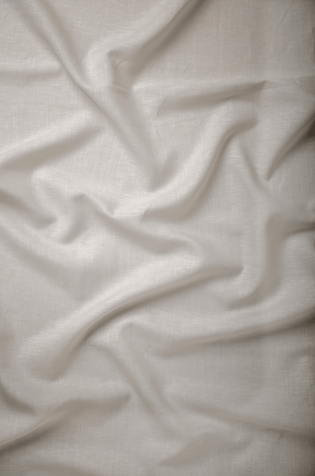 Flat lay of Registan 60 lea pure linen fabric in soft off-white, showing the weave. Sold by the metre by Tyra